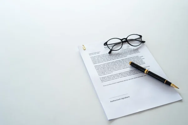 White table with paper contract detail and empty space to sign authorized signature. White table with paper contract detail and empty space to sign authorized signature.